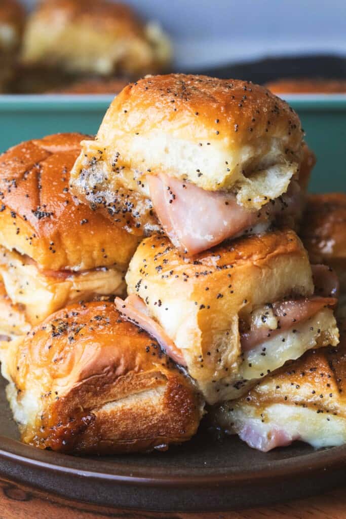 Ham and cheese sliders are stacked on a plate, toasty, melty and ready to enjoy for our 15 Best Fall Recipes