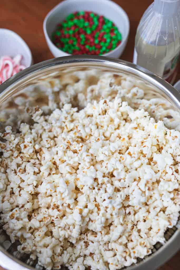 A large metal bowl is filled with fresh popped popcorn.