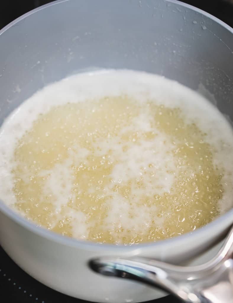Ingredients bubble and boil in a pot on the stovetop.